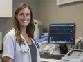 Lekarka z uśmiechem przy monitorze EKG, który pokazuje zapis serca. Czy nerwica serca wyjdzie na EKG?