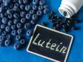 Jagody i kapsułki z luteiną na oczy. Na tabliczce napis "Lutein".