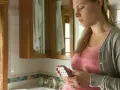 Zmartwiona ciężarna kobieta trzyma blister tabletek. Czy amoksycylina w ciąży jest bezpieczna?
