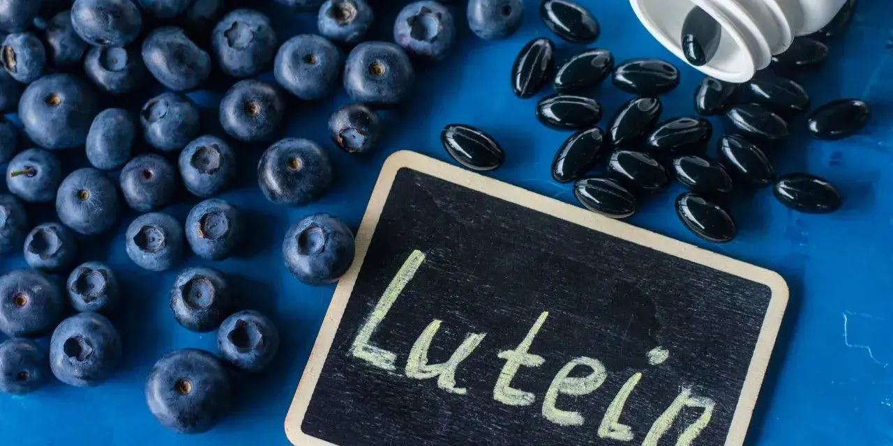 Jagody i kapsułki z luteiną na oczy. Na tabliczce napis "Lutein".