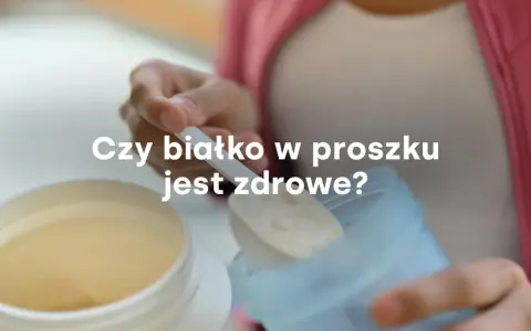 Dłoń nabiera miarkę białka w proszku z dużego pojemnika. Czy białko w proszku jest zdrowe?