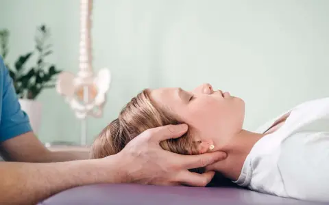 Delikatna terapia krzyżowo czaszkowa dla ulgi w napięciu. Terapeuta delikatnie uciska głowę pacjentki.
