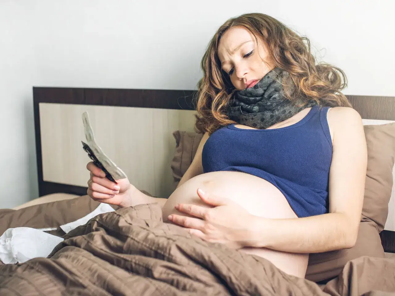 Ciężarna kobieta z bólem gardła szuka w internecie informacji: co na ból gardła w ciąży.